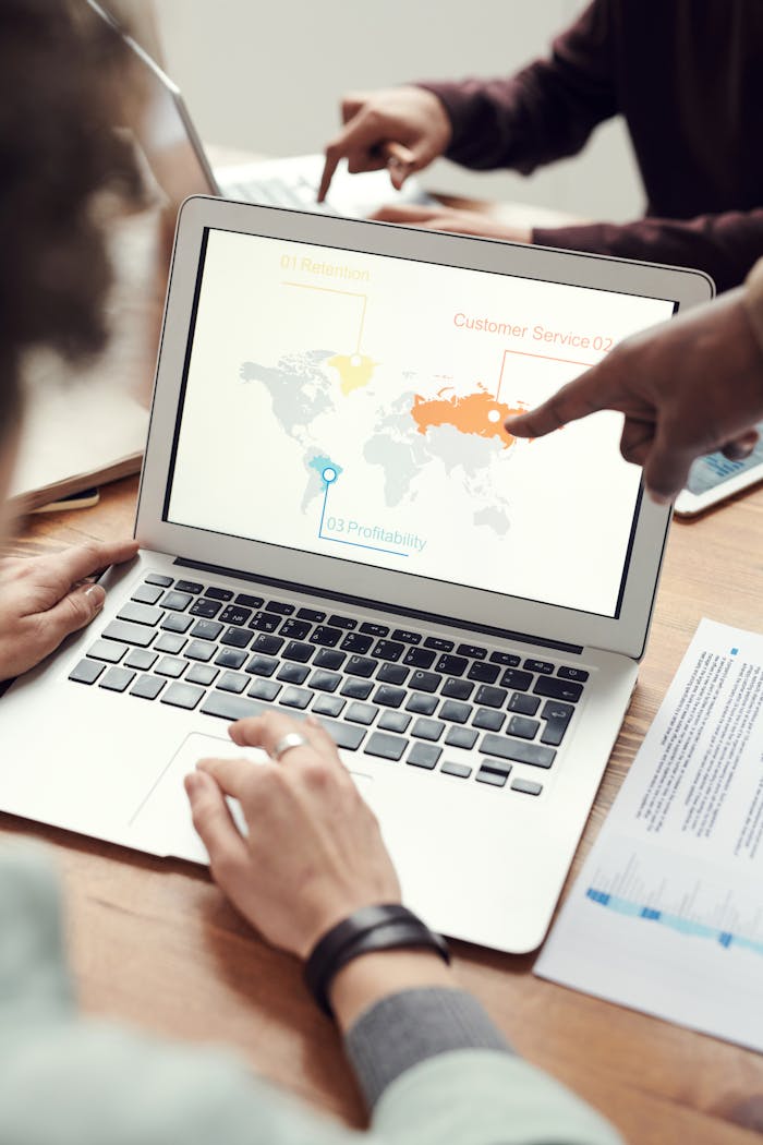 hero-img Colleagues in discussion around a laptop showing a global business presentation.